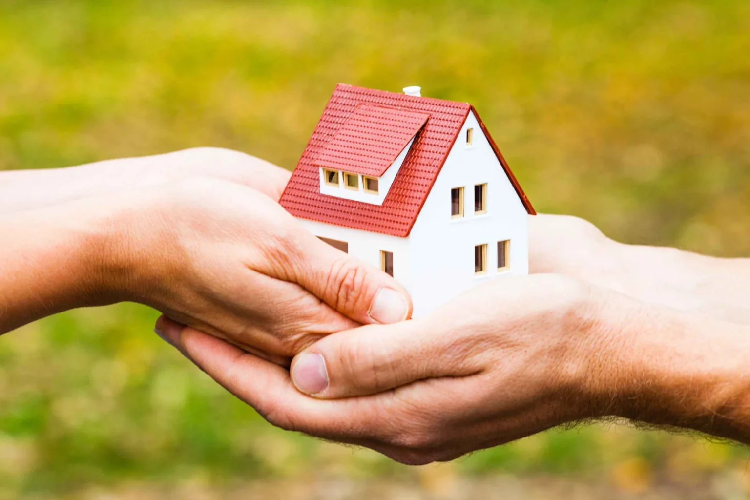Hands Holding a Model Home